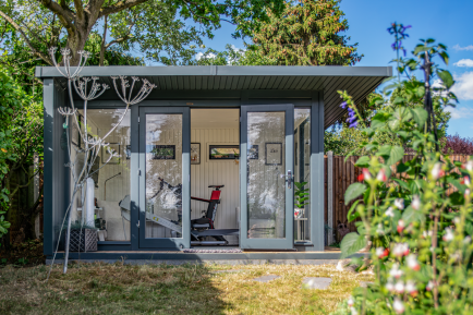 A garden gym with tall floor to ceiling windows and double doors at the front